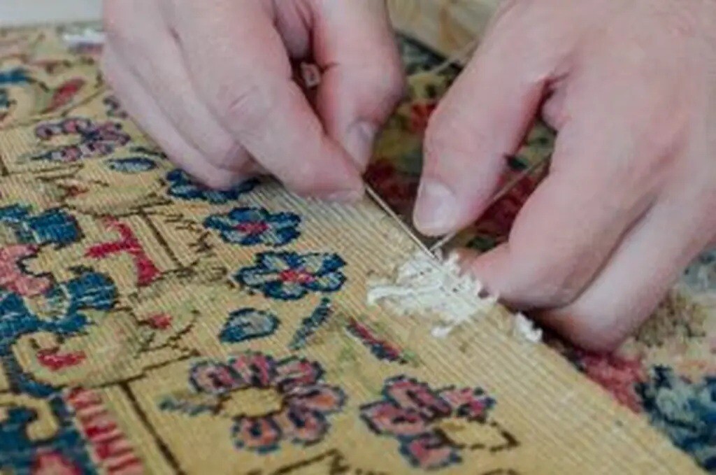 Alternativtext: Fachkundige Handarbeit bei der Orientteppich-Restaurierung – professionelle Wiederherstellung für die Versicherungsabwicklung