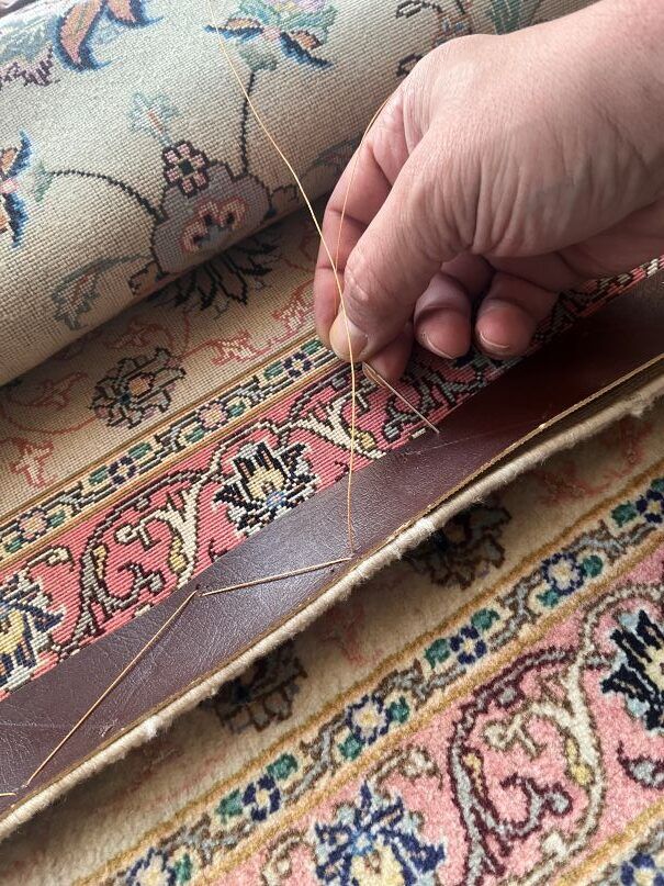 Hand näht Lederkante an orientalischen Teppich